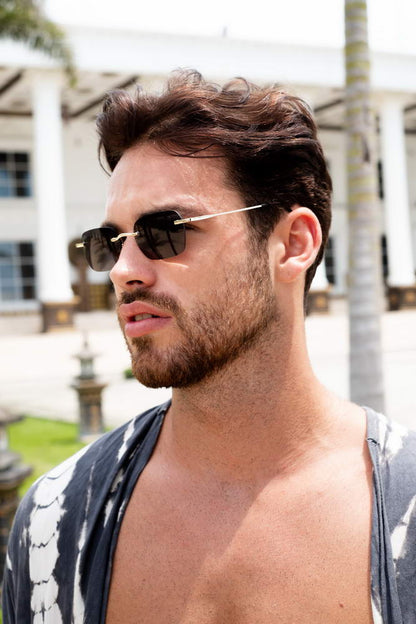 A man on a sunny day wearing Black Rimless Rectangle Sunglasses