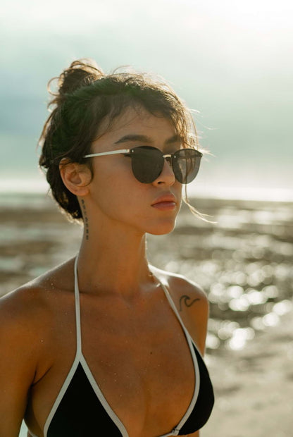 Women wearing black round sunglasses gold slim metal frame UV400 protection bold glamorous retro summer beach holiday festival city style free UK Europe delivery Sunglass Station