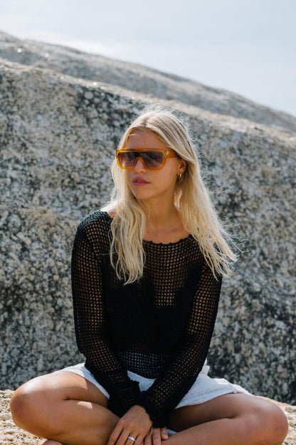 Woman wearing bold oversized shield party sunglasses in editorial outdoor setting — maximalist eco eyewear worn with confidence, free delivery across UK & Europe, UV400 100% recycled polyester