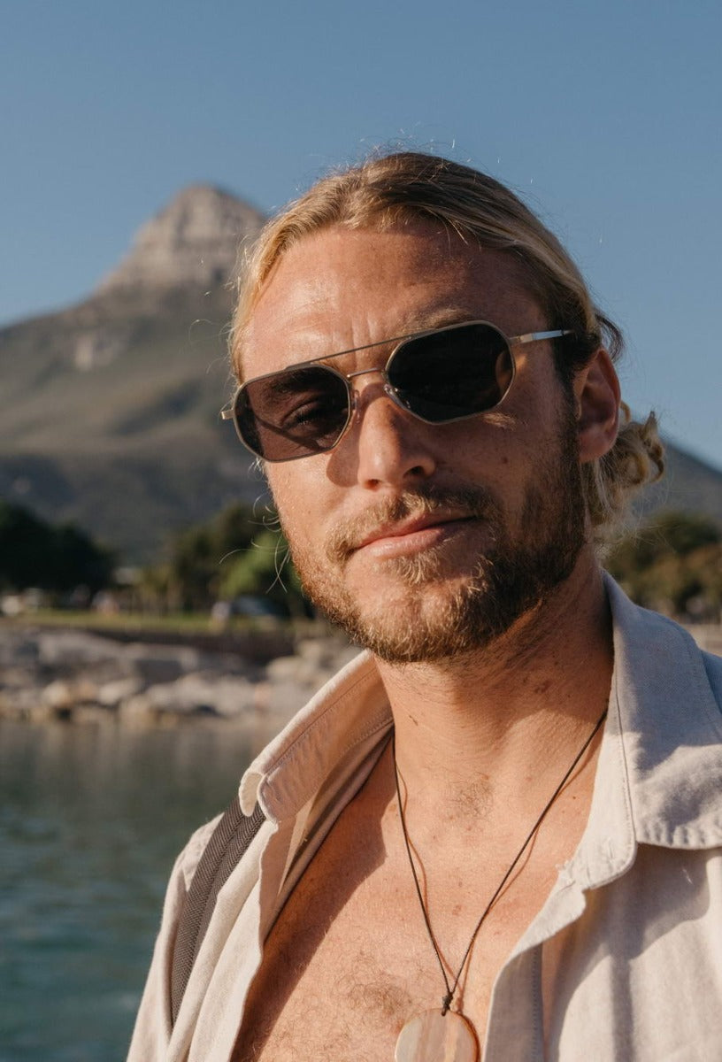 man wearing brown sunglass in london beach