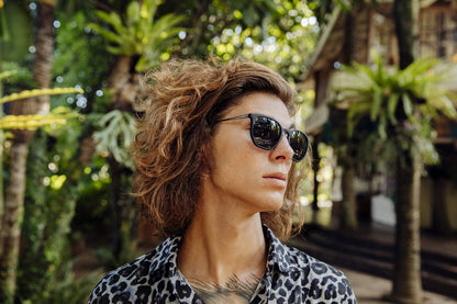 Wearing chic round sunglasses men dark frame polycarbonate black smoke lens UV400 protection bold glamorous chic sophisticated summer city outdoor beach holiday style free UK Europe delivery Sunglass Station