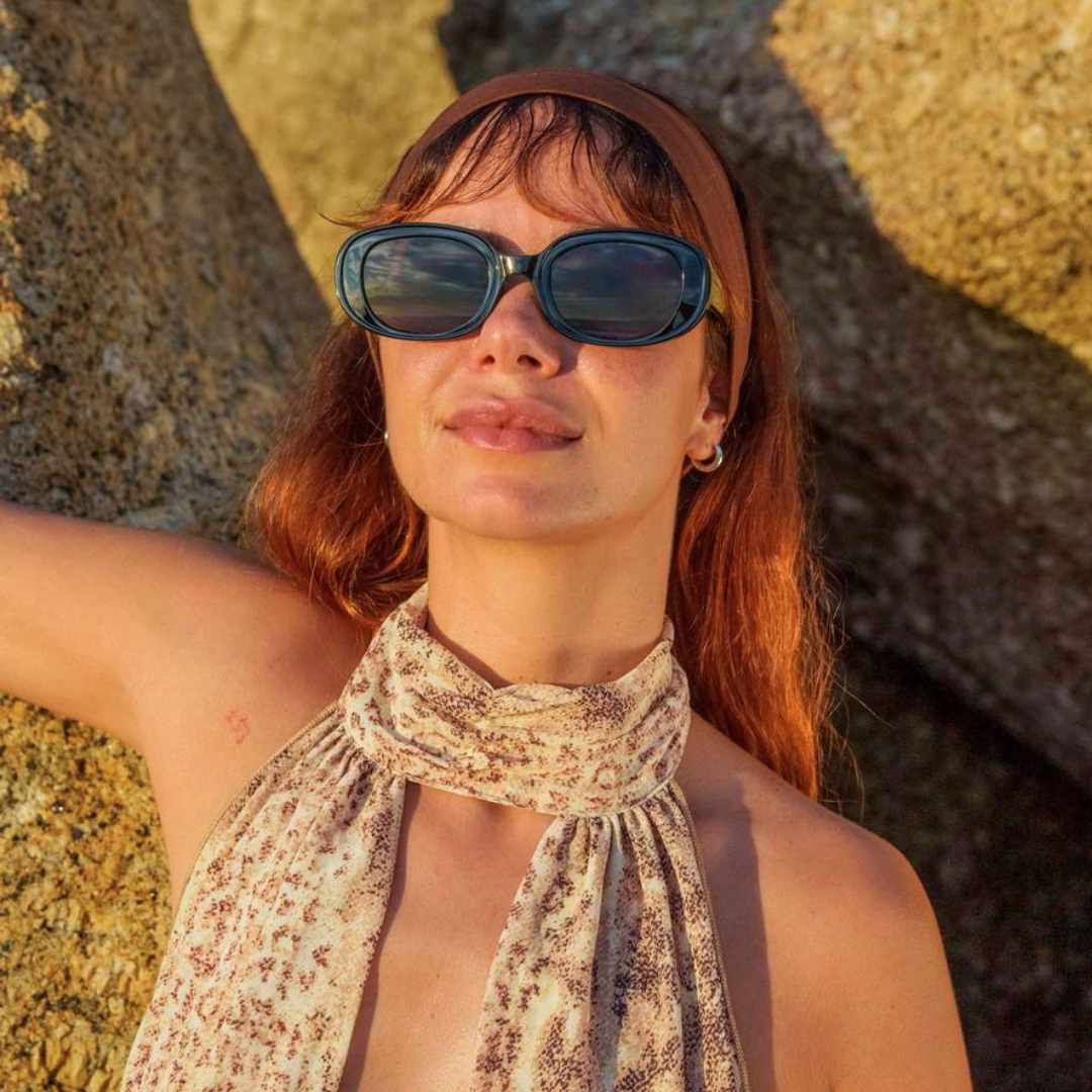 a woman wearing bold chunky thick frame sunglasses in summer