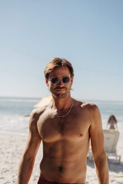 Men wearing eco Greece geometric round sunglasses gold metal frame black lens UV400 protection sustainable recycled eyewear beach holiday summer free UK Europe shipping Sunglass Station