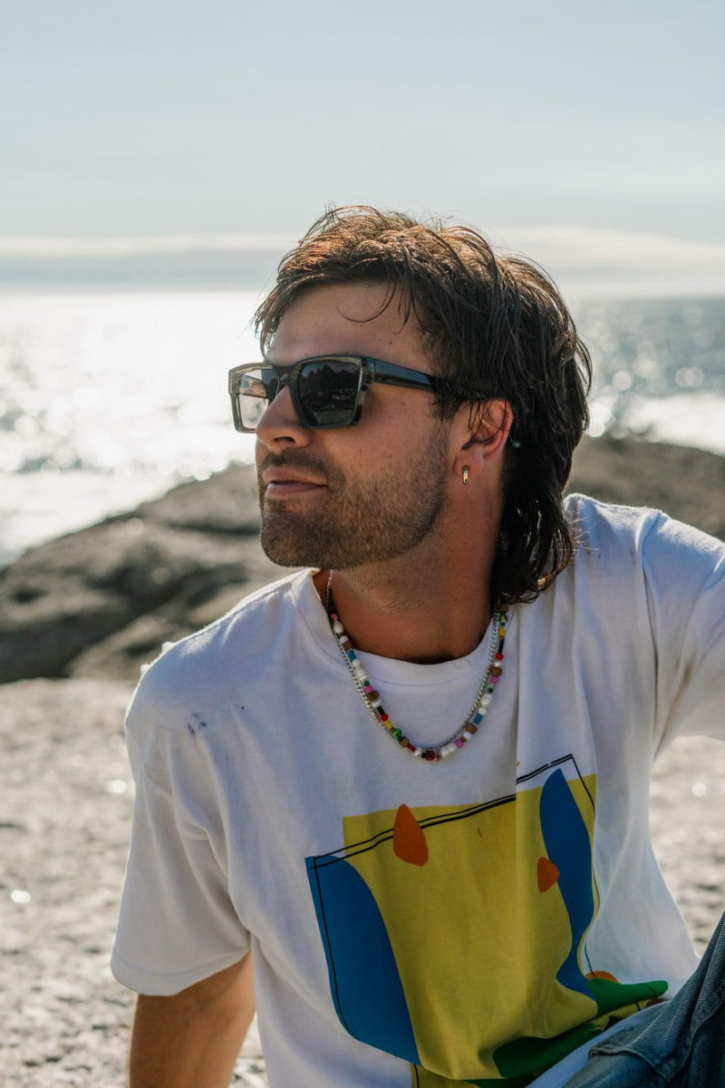 man wearing square shape wayfarers at beach