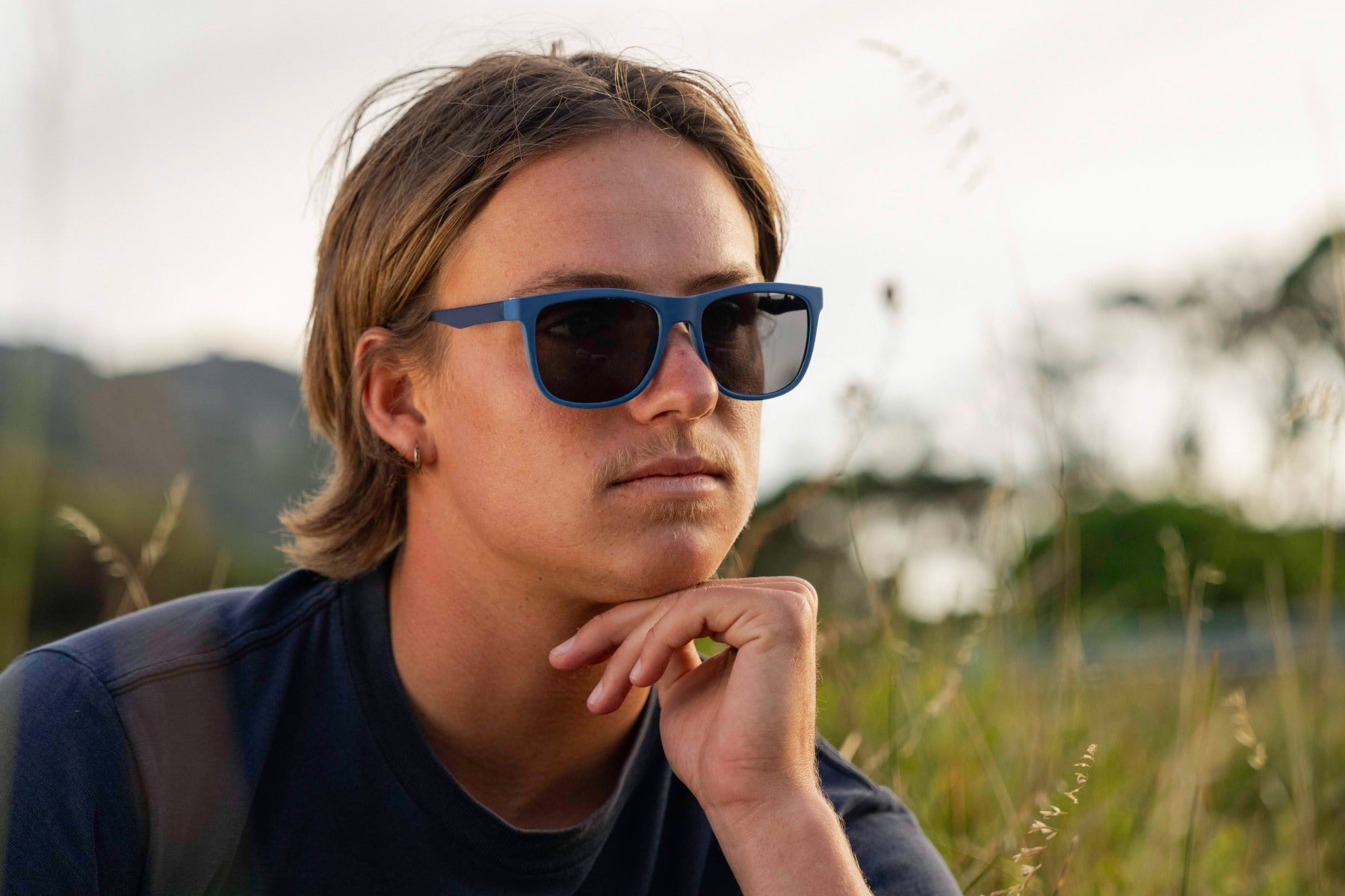 man wearing blue sleek frame wayfarer sunglass with black lens 