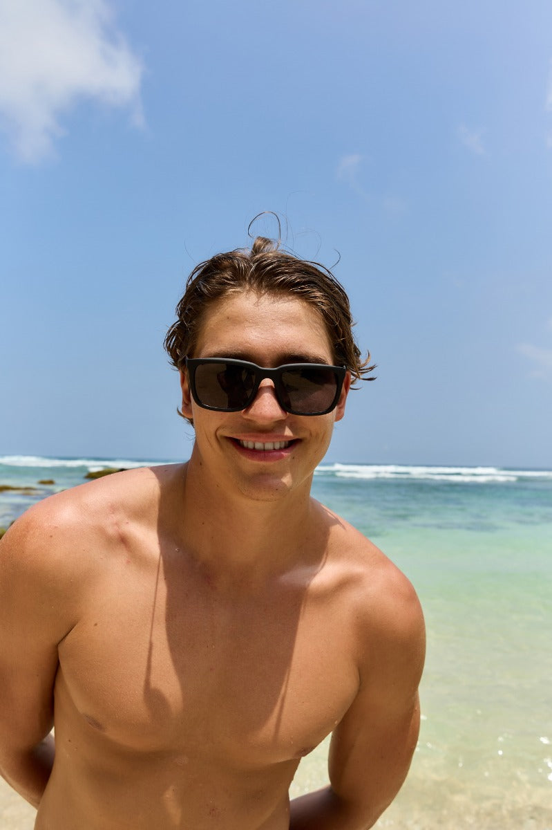 man wearing black sunglasses at london beach in summers