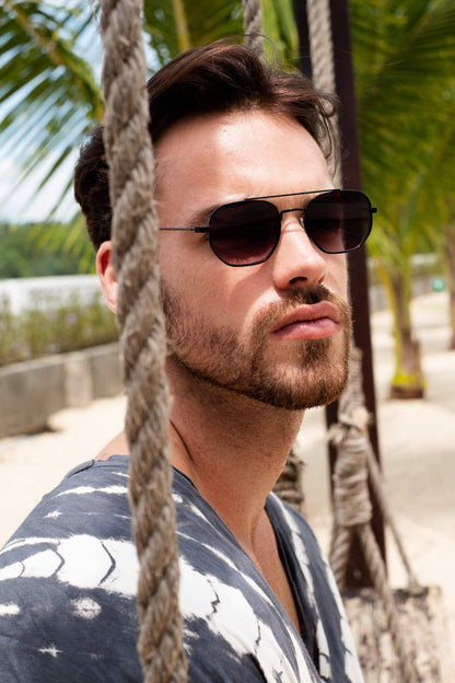 man wearing metallic geometric frame sunglass at croatia coastal beach