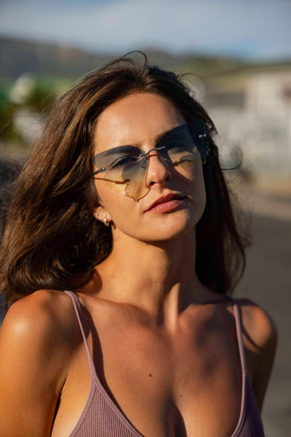 Woman wearing rimless butterfly party sunglasses outdoors — bold statement eyewear for festivals, holidays and summer parties | Sunglass Station