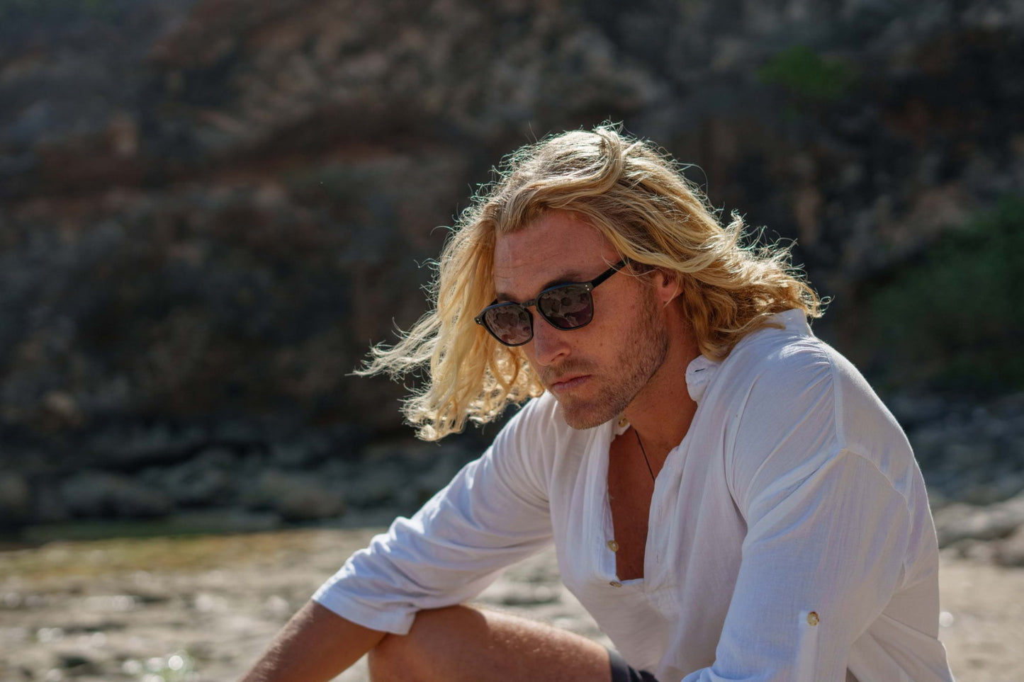 man wearing modern styling sleek black sunglasses at european coastal area