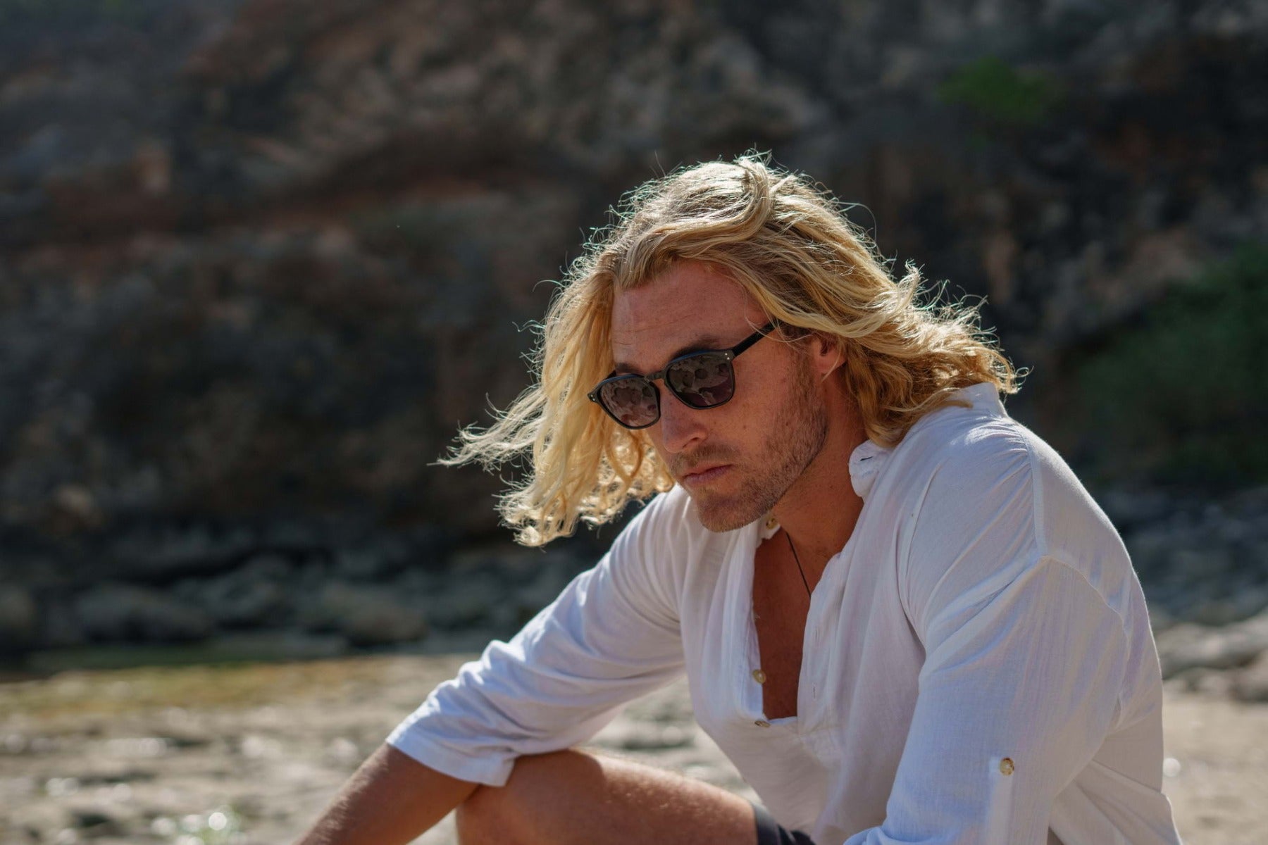 man wearing modern styling sleek black sunglasses at european coastal area