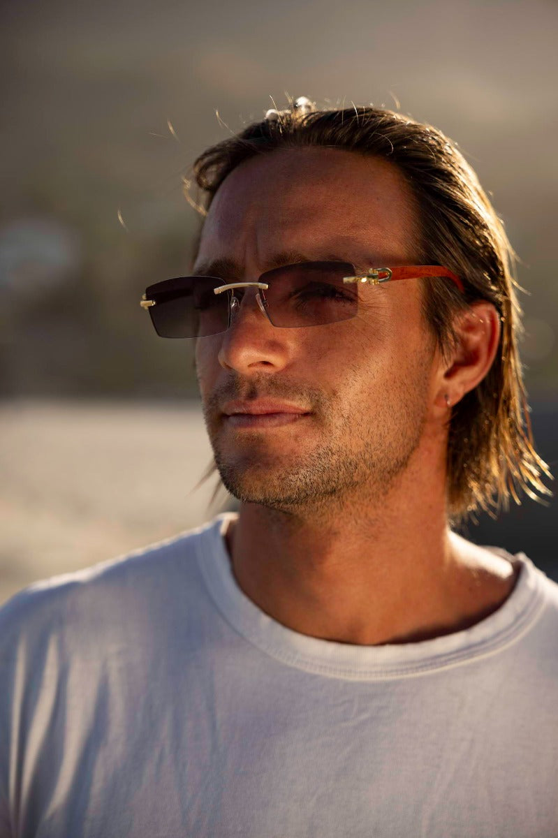 Man wearing sleek rimless rectangle sunglasses with elegant gold metal frame – lightweight frameless retro shades for everyday city wear and weekend travel, Sunglass Station free UK and Europe shipping