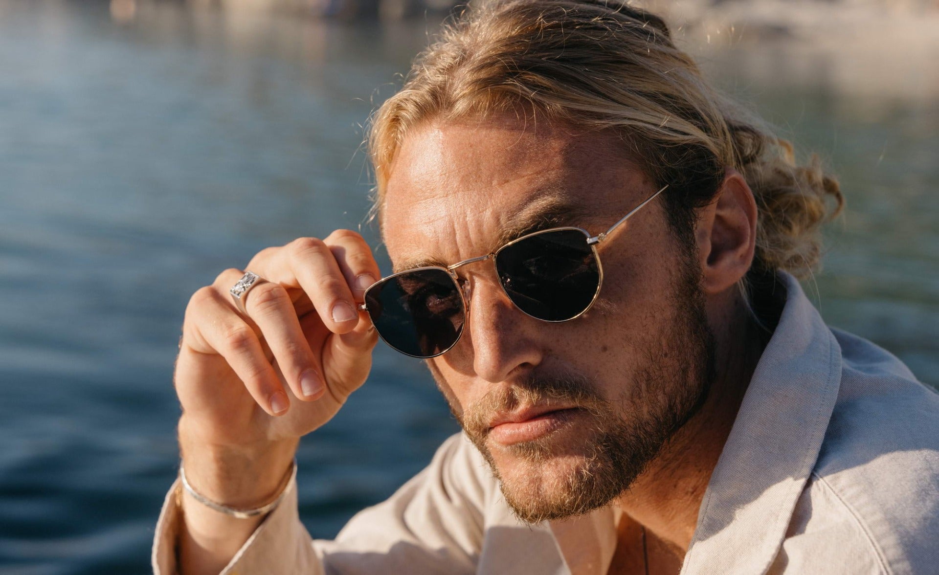 Man wearing aviator pilot sunglasses outdoors, suitable for casual outfits and travel styling