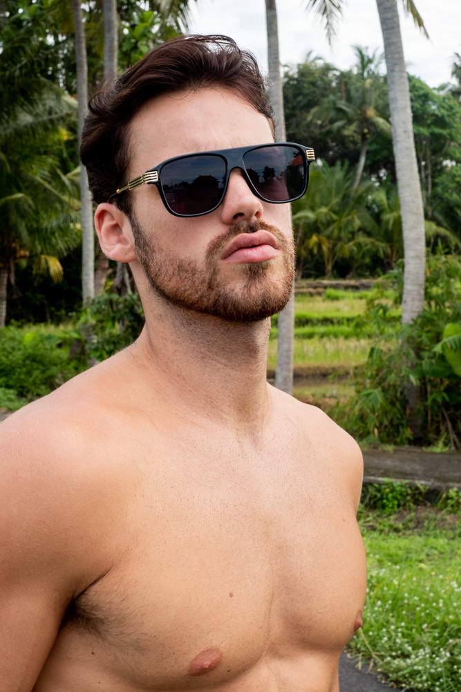Man wearing retro aviator sunglasses outdoors with a confident modern style and relaxed lifestyle look