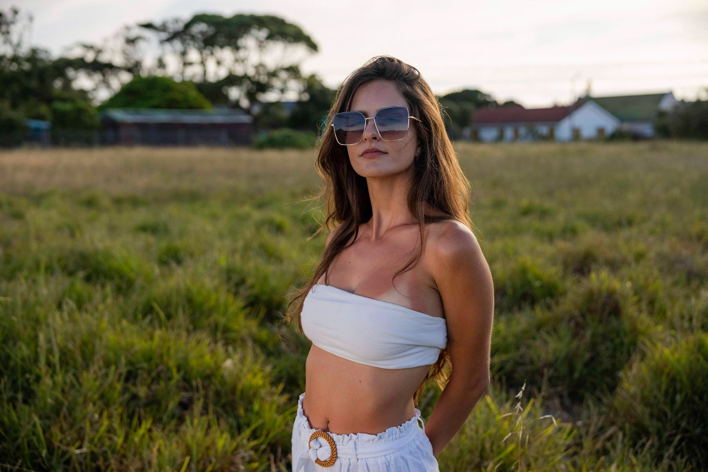 Woman wearing brown oversized sunglasses with gold frame in outdoor setting, stylish eco sunglasses for summer fashion, travel outfits and warm weather looks