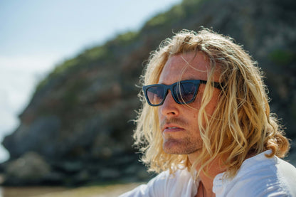 Close up of cat eye sunglasses worn by a man highlighting frame shape and tinted lenses