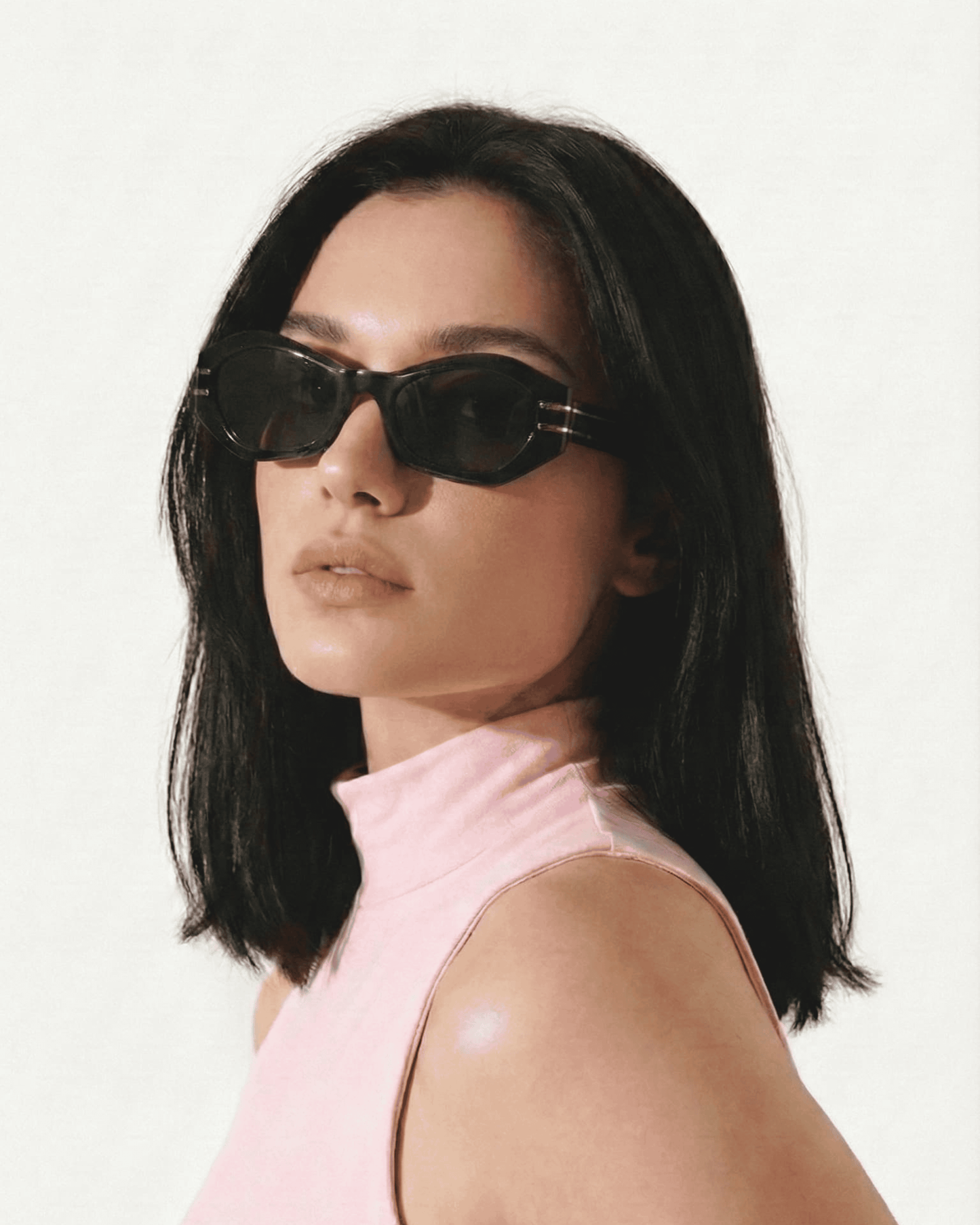 Woman wearing geometric cat eye sunglasses with tinted lenses in a modern everyday style