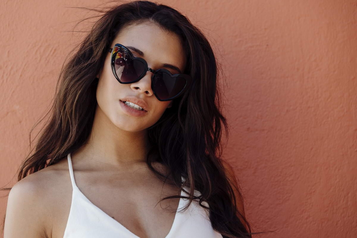 Woman wearing heart shaped sunglasses with stylish outfit and modern look