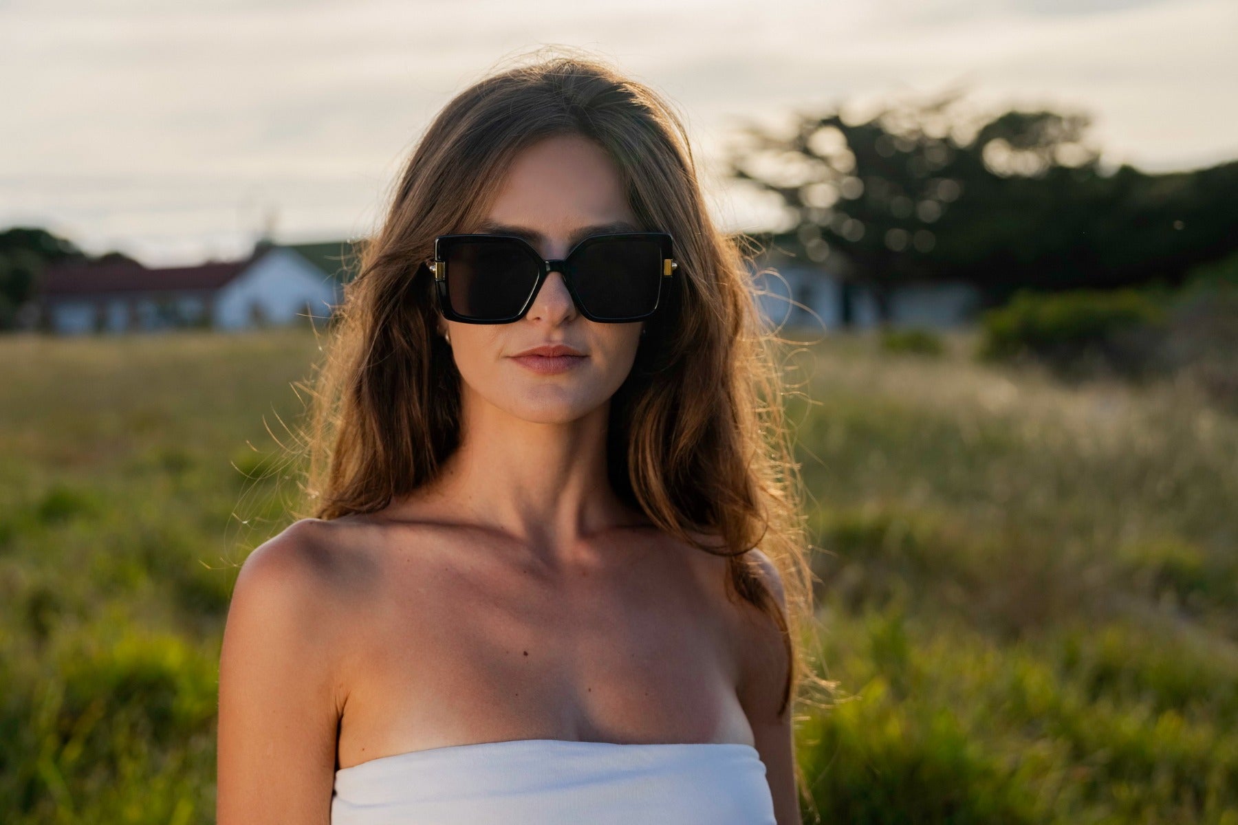 Woman wearing oversized Madrid sunglasses in brown tones, stylish summer look for travel outfits, sunny days and relaxed city fashion