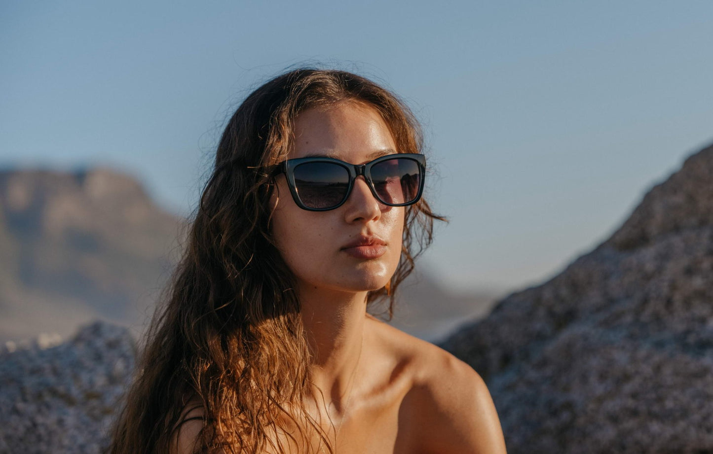 Woman wearing modern cat eye sunglasses with chunky frame and tinted lenses