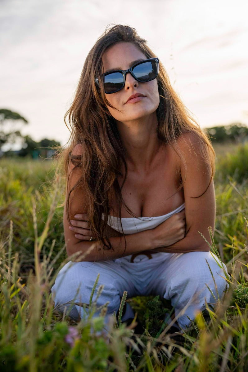 Woman wearing oversized rectangle sunglasses by Sunglass Station, stylish unisex eyewear with a modern European street style look