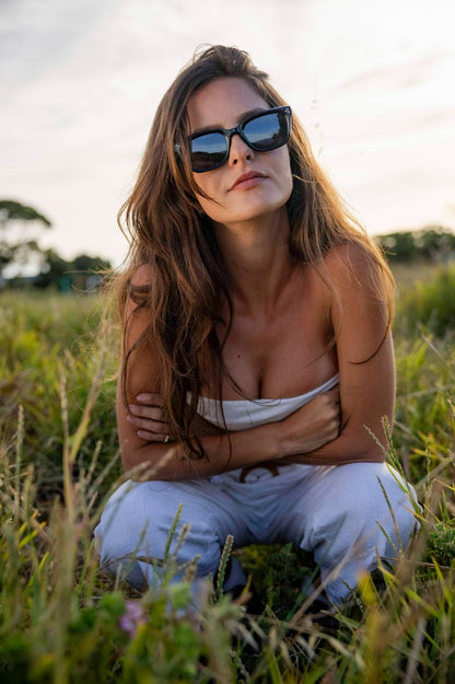 Woman wearing oversized rectangle sunglasses by Sunglass Station, stylish unisex eyewear with a modern European street style look
