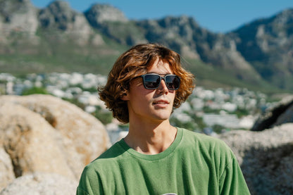 Retro aviator sunglasses styled in a casual outdoor setting, perfect for relaxed everyday fashion and travel looks