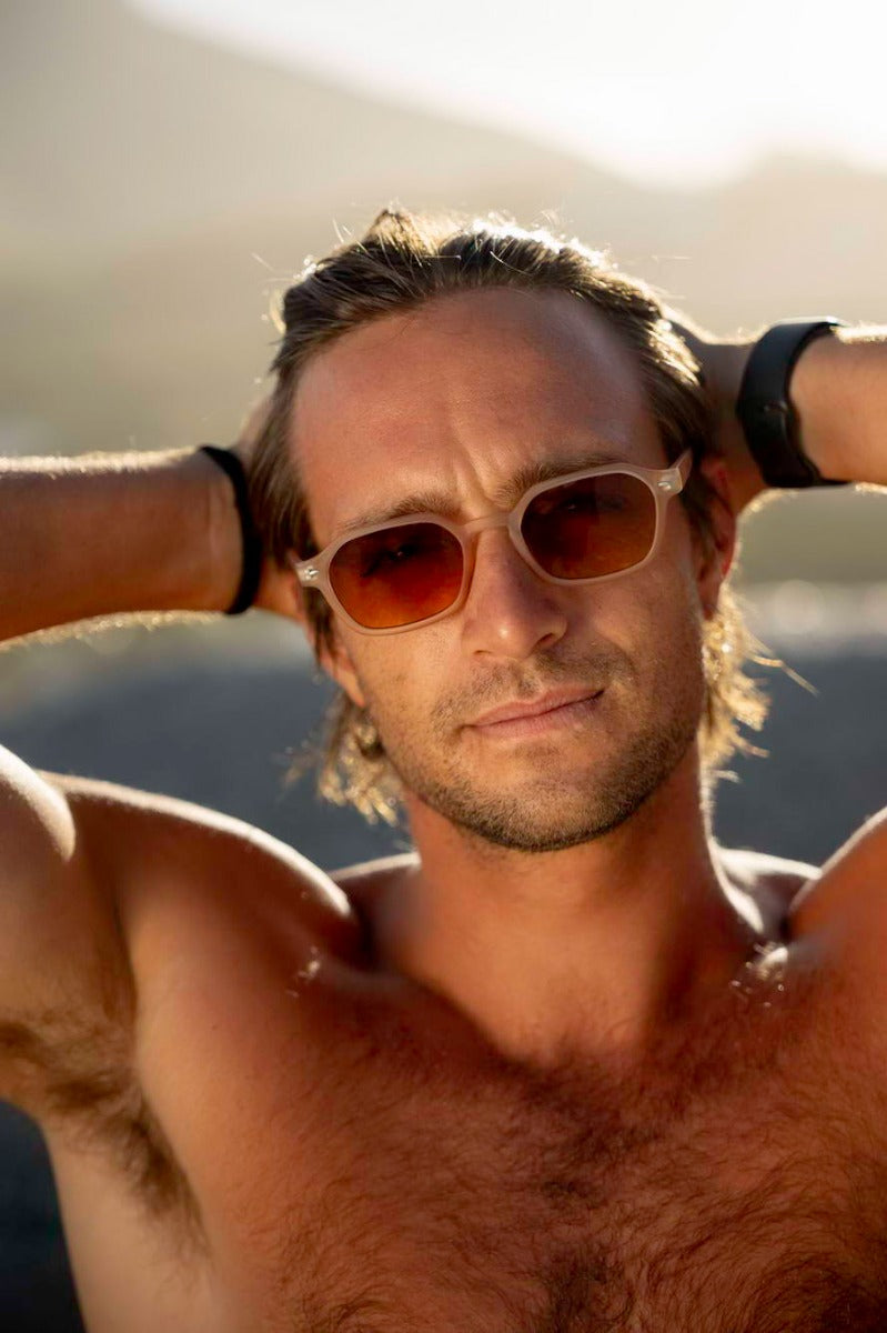 Man wearing tinted rectangle sunglasses by Sunglass Station, unisex eco-friendly eyewear designed for summer outfits and outdoor use