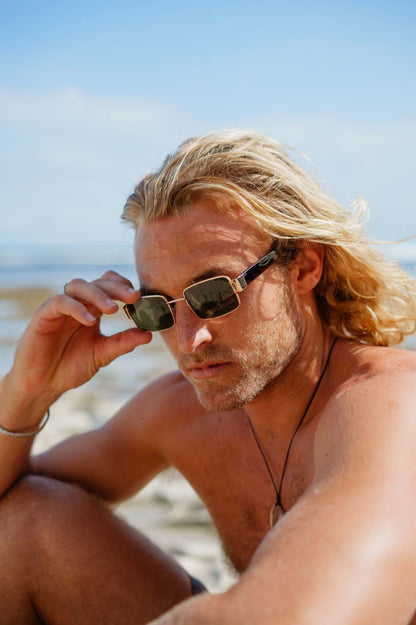 man wearing vintage metal frame rectangle sunglasses by Sunglass Station, stylish unisex eyewear with a retro-inspired look for outdoor wear