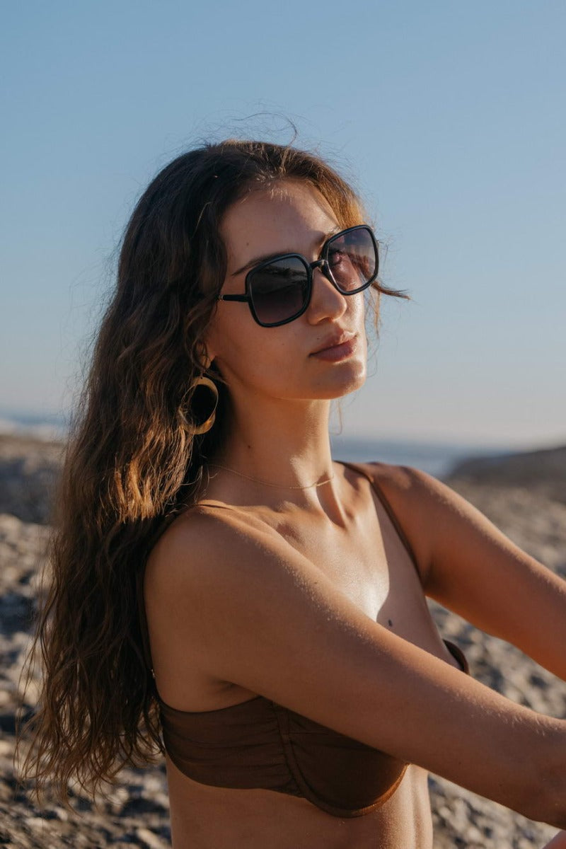 Woman wearing black oversized sunglasses, stylish eco friendly eyewear for sunny holidays, beach outfits and casual everyday fashion