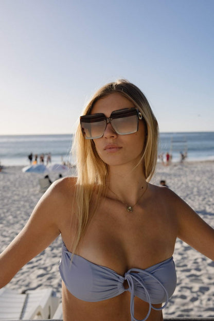 Woman wearing brown oversized sunglasses with luxury beach style outfit, chic fashion eyewear for holidays, travel and modern summer looks