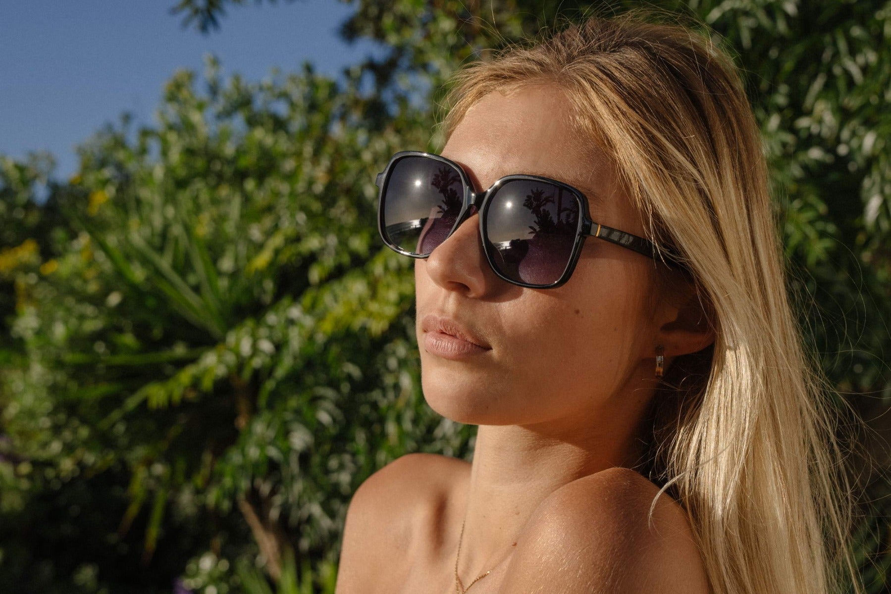 Woman wearing oversized sunglasses with modern frame design, stylish eyewear for beach holidays, travel outfits and sunny days