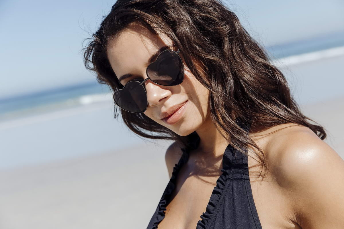 woman wearing black heart sunglasses at london beach party
