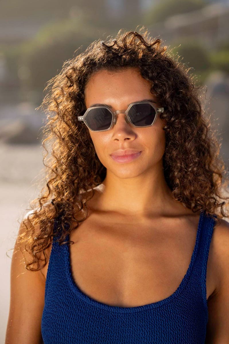woman wearing round geometric sunglasses at santorini beach